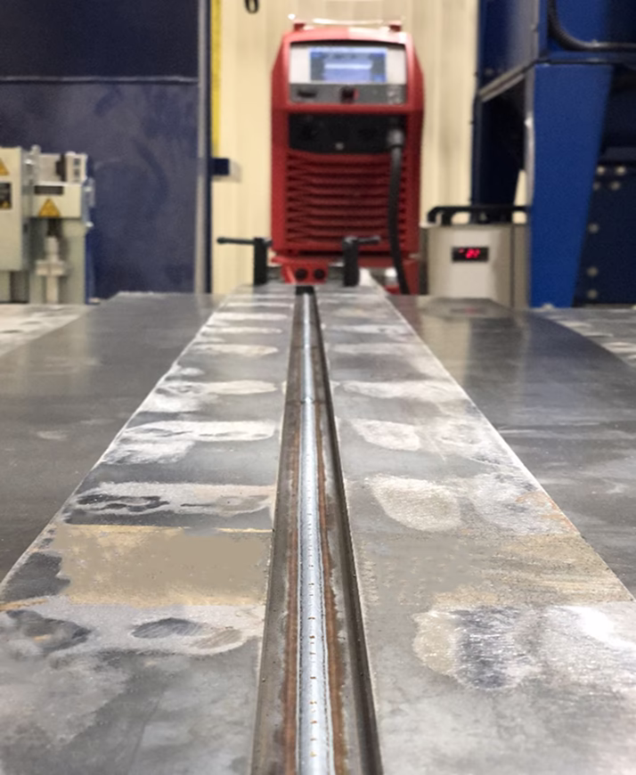 Longitudinal seam welding process of a sample on the welding table, View 2